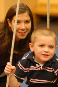 Woman behind child in swing